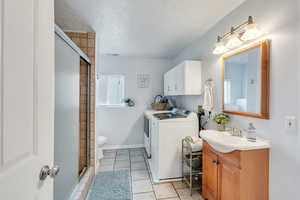 Bathroom featuring vanity, an enclosed shower, independent washer and dryer hook ups, and toilet