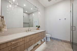 Bathroom featuring vanity, walk in shower, tile patterned floors, and toilet