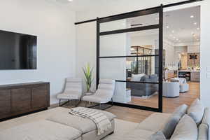 Living room with a barn door and light hardwood / wood-style flooring