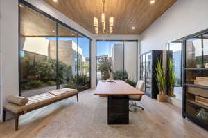 Home office featuring an inviting chandelier, wooden ceiling, and light hardwood / wood-style floors