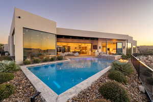 Pool at dusk featuring a patio area