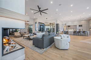 Living room featuring a high ceiling and light hardwood / wood-style flooring