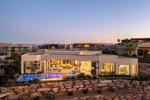 Back house at dusk featuring an outdoor hangout area and a patio area