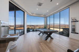 Rec room featuring expansive windows, pool table, a mountain view, and light wood-type flooring