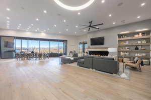 Living room featuring built in shelves, a healthy amount of sunlight, and light wood-type flooring