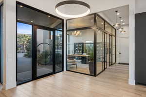 Interior space featuring light hardwood / wood-style flooring, expansive windows, and a chandelier