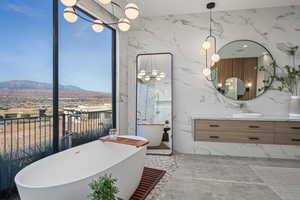 Bathroom featuring vanity, a bathing tub, and a mountain view