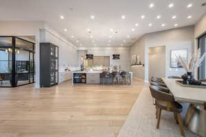 Kitchen featuring hanging light fixtures, light hardwood / wood-style floors, a breakfast bar, and a large island with sink