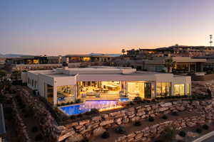 Back house at dusk with a patio and outdoor lounge area