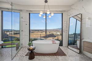 Bathroom featuring vanity, a bathtub, and a chandelier