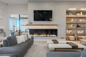 Living room with built in shelves and hardwood / wood-style floors