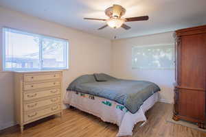 Bedroom with ceiling fan and light wood-type flooring