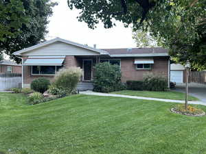 Ranch-style home featuring an outbuilding, a garage, and a front lawn