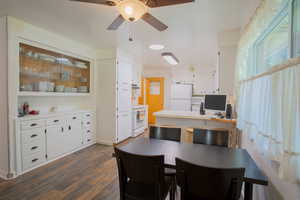 Dining room with dark hardwood / wood-style flooring and ceiling fan