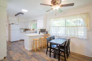 Dining area with ceiling fan, sink, and dark hardwood / wood-style flooring