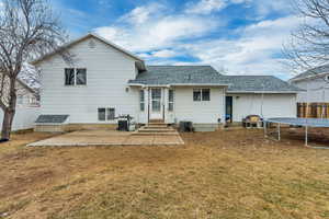 Back of house featuring a patio, a yard, central AC, and a trampoline