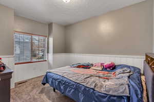 Carpeted bedroom with a textured ceiling