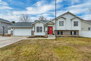 Split level home with a garage and a front lawn