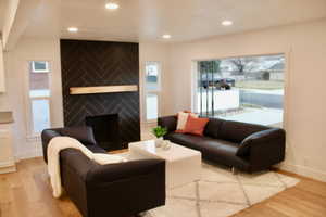 Living room with a fireplace and light hardwood / wood-style floors