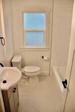 Full bathroom featuring vanity, plenty of natural light, tile patterned floors, and toilet