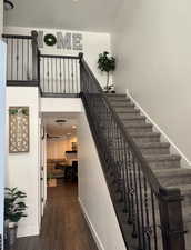 Staircase featuring a towering ceiling and hardwood / wood-style floors