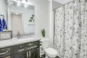 Bathroom with a shower with curtain, vanity, and toilet