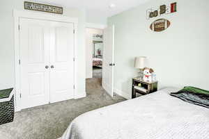 Carpeted bedroom with a closet