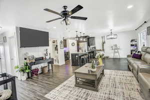 Living room featuring hardwood / wood-style floors and ceiling fan with notable chandelier