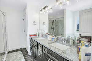 Bathroom with vanity, wood-type flooring, and an enclosed shower