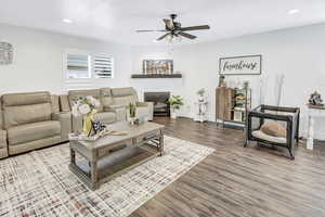 Living room featuring wood-type flooring and ceiling fan