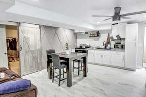 Dining room with ceiling fan, a barn door, and sink