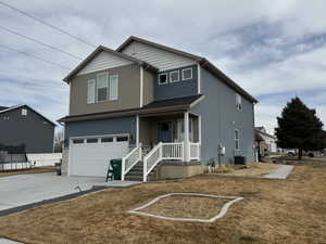 View of front of property with a trampoline, central AC unit, a garage, and a front yard