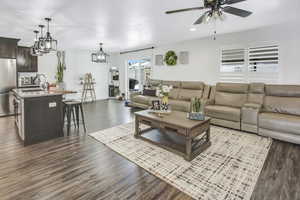 Living room featuring dark hardwood / wood-style flooring, sink, and ceiling fan