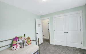 Bedroom with light carpet and a closet