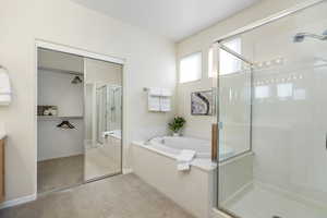 Bathroom featuring shower with separate bathtub and vanity