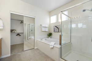 Bathroom with a shower stall, a garden tub, and vanity