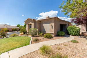 View of front facade featuring stucco siding and a front lawn