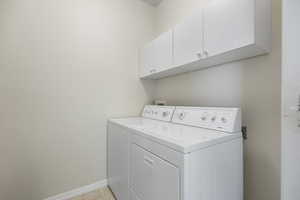 Laundry room with cabinets and washing machine and clothes dryer