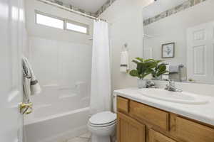 Full bathroom featuring tile patterned flooring, shower / bath combo, vanity, and toilet