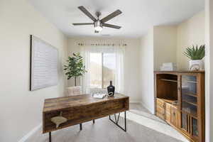 Home office with baseboards, light colored carpet, and ceiling fan