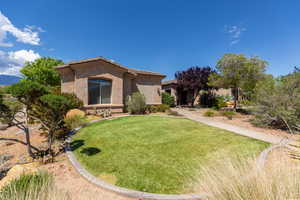 View of front of home with stucco siding, a front lawn, and a tiled roof