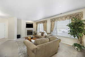 Living room featuring light carpet and a tile fireplace