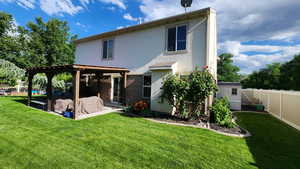 Back of house with a pergola, a yard, a patio area, and a storage shed