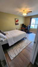 Bedroom featuring dark wood-type flooring and ceiling fan