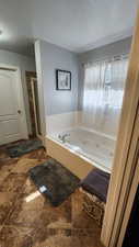 Bathroom featuring separate shower and tub and a textured ceiling