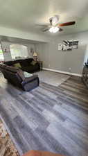 Living room featuring wood-type flooring and ceiling fan