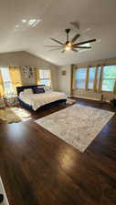 Unfurnished bedroom with lofted ceiling, dark wood-type flooring, and ceiling fan