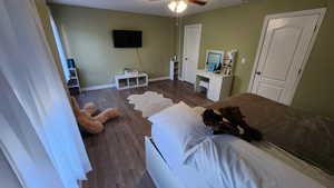 Bedroom with dark hardwood / wood-style flooring and ceiling fan