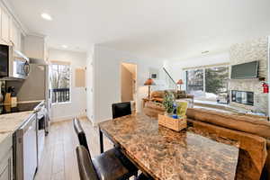 Dining space featuring a large fireplace and light hardwood / wood-style floors