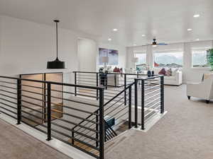 Staircase with plenty of natural light and carpet